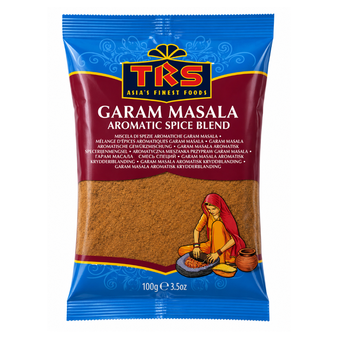 A 100g package of TKS Garam Masala aromatic spice blend. The packaging features a blue top and bottom border, a dark red central band with the brand name 'TRS' in gold and red, and a clear window showing the brown spice blend inside.