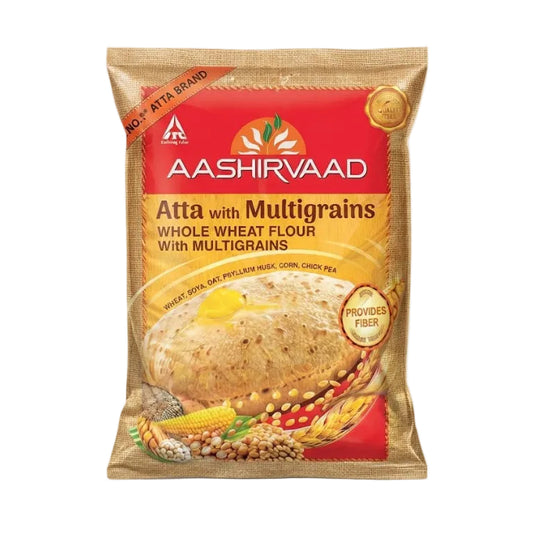 Aashirvaad Atta with Multigrains whole wheat flour in a resealable stand-up pouch. The packaging features a red and gold design with an illustration of a flatbread topped with butter and a yellow splash, surrounded by multigrain ingredients like corn, soy, lentils, and wheat.