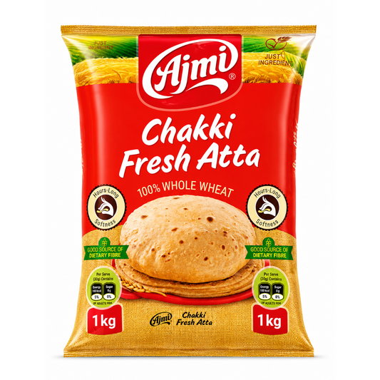 A 1 kg bag of Ajmi Chakki Fresh Atta whole wheat flour, featuring a bright red and golden-yellow packaging design with a photo of a cooked flatbread in the center.