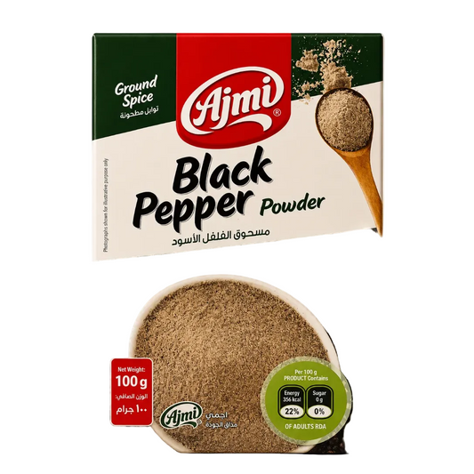 A package of Ajmi Ground Black Pepper Powder, 100g, shown against a solid beige background. The packaging features a red and white Ajmi logo, a green and white top section, and a large image of black peppercorns at the bottom with a bowl of the ground pepper powder.