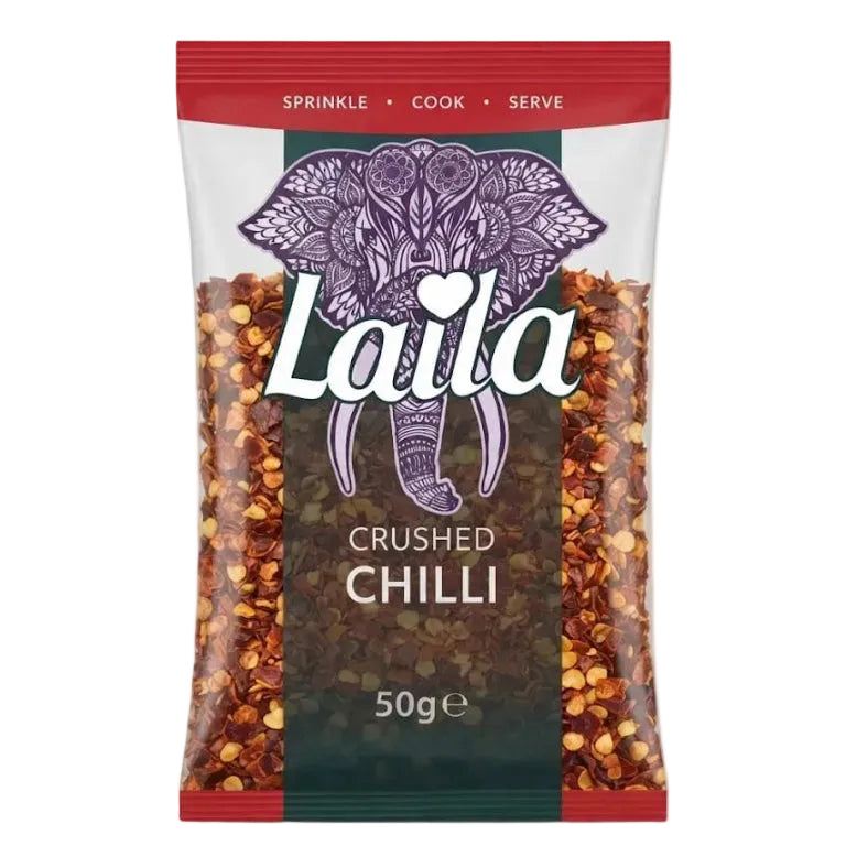 A 50g bag of Laila Crushed Chilli flakes, featuring a clear plastic bag with red and dark green sections, an ornate purple elephant graphic, and visible chili flakes inside.
